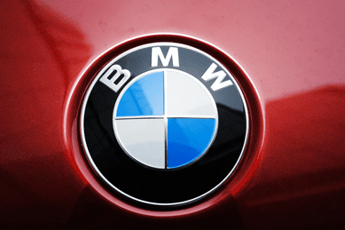 A close-up of a BMW logo of a red BMW car.